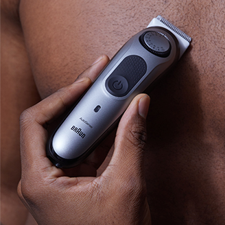 man using trimmer to shave chest
